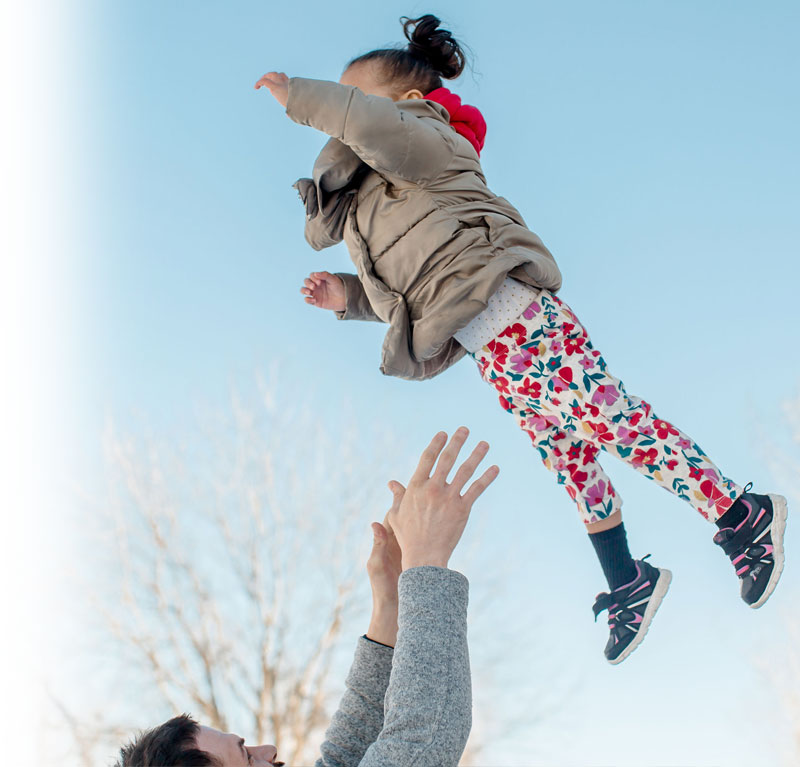 Daughter being thrown up in the air by her father